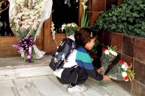 Una nia deposita flores en el portal donde viva Portero, das despus de su asesinato. | El Mundo