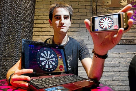 Iban García muestra su aplicación en el portatil y su móvil. | Iñaki Andrés