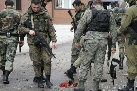 Soldados observan los restos del insurgente que se inmol en el Parlamento checheno. | Ap