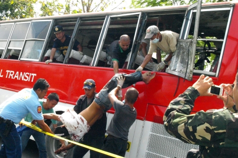 Policas filipinos sacan a un cadver del autobs atacado en Cotabato del Norte. | Afp