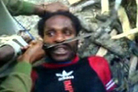 Soldados indonesios torturando a un joven papuano. | Survival International