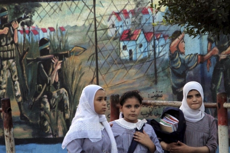 Estudiantes palestinas ante un mural en Gaza. | Efe