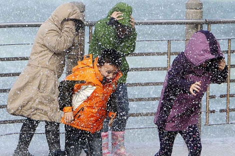 Varias personas intentan protegerse de la lluvia en San Sebastin el pasado 1 de noviembre. | Efe