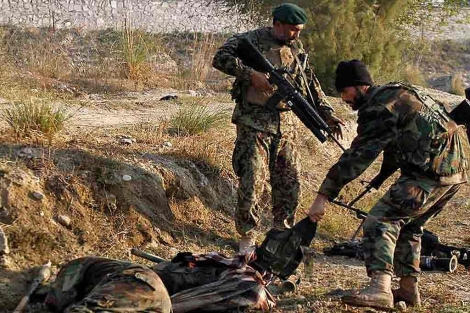 Soldados del Ejrcito Nacional afgano examinan a dos presuntos talibanes tras el atentado base, en Jalalabad. | AP