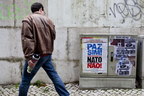 Un hombre mira un cartel que dice "Paz sí, OTAN no" en Lisboa. | Afp