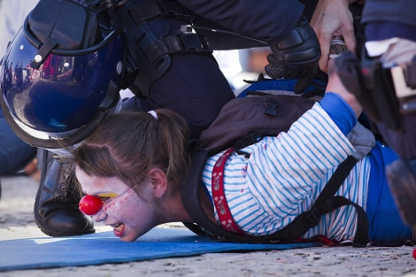 Un polica inmoviliza a una activista tras detenerla en Lisboa. | AP