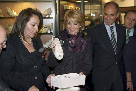 Aguirre dona el par de zapatos acompaada por la alcaldesa de Elda y el presidente Camps. | Efe
