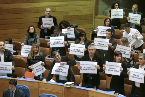 Diputados socialistas y nacionalistas, con los carteles durante el pleno. | Efe