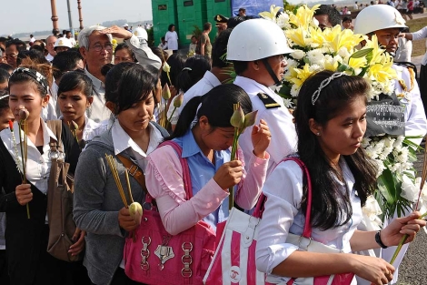 La gente hace cola para rendir su ofrenda floral a las vícitimas. | Afp