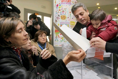 Un padre con su hijo emite su voto en un colegio del Eixample barcelons. | Efe