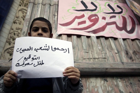 Un nio pide "compasin por el pueblo egipcio" en una protesta contra el fraude en El Cairo. AFP