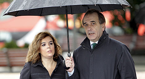 Los portavoces de PP y PSOE se protegen de la lluvia en el homenaje. | Efe