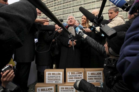 El comisario Dalli atiende a los medio delante de la caja de firmas.| Efe