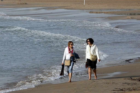Dos mujeres pasean hace dos días en la playa de Salou. | Efe