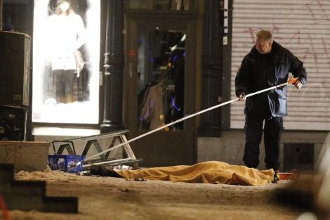 Un polica remueve pedazos de bomba y restos del supuesto suicida . | Efe