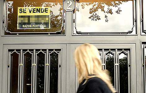 Cartel 'Se vende' en la entrada a un edificio de viviendas de Madrid. | Bernardo Díaz