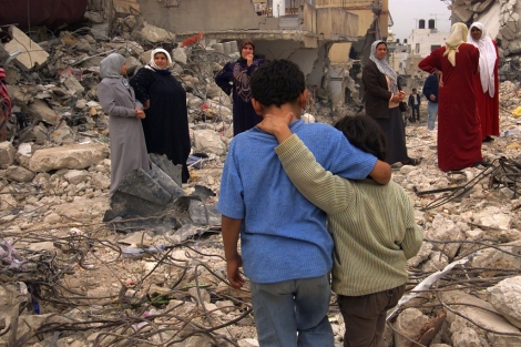 Palestinos caminando sobre edificios destruidos.| Jerome Delay