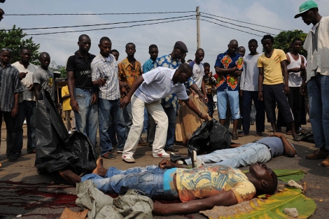 Vctimas de la violencia en Costa de Marfil tendidas en una calle de Abiyn. | Afp