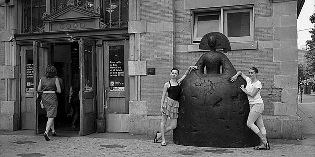 Dos chicas abrazan una escultura de Manolo Valdés. | Andrea Santolaya