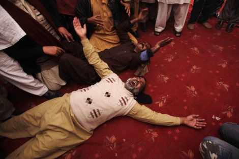 Dos hombres lloran en el funeral de Salman Tasir en Lahore. | Ap