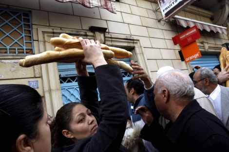 Una mujer logra comprar pan en una de las panaderas tunecinas abiertas. | AP