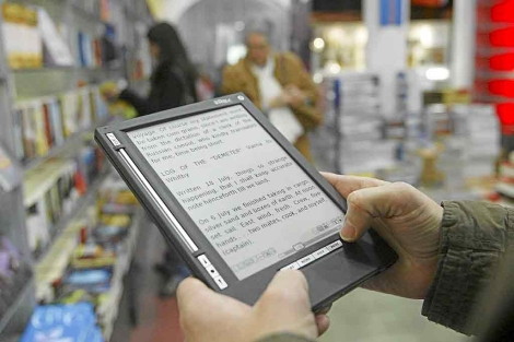 Un usuario lee en un e-reader en una librera de Barcelona. | Efe