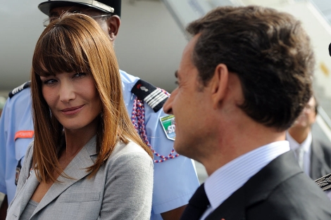 Bruni, junto a Sarkozy en un aeropuerto. | Afp