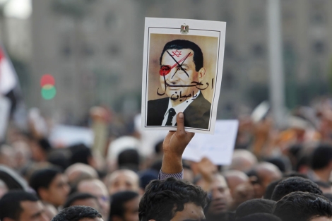 Un manifestante con un cartel con la cara de Mubarak pintada.| Reuters.VEA MÁS IMÁGENES