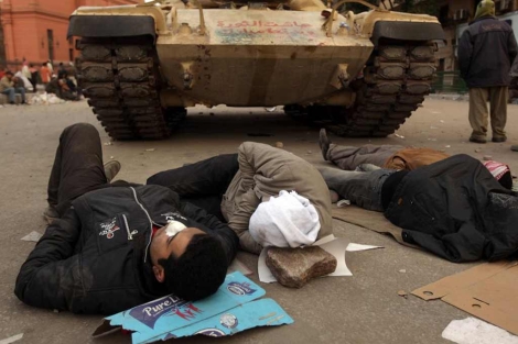 Egipcios heridos en los combates a los pies de un tanque. | AFP
