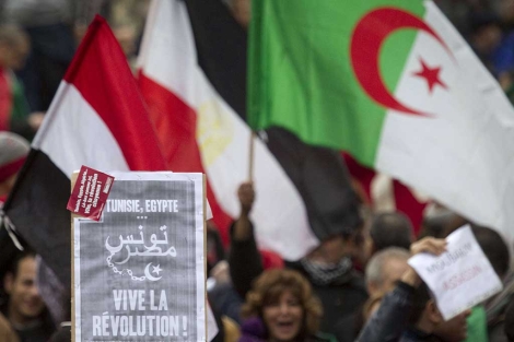 Un cartel donde se lee "Viva la revolucin", junto a banderas egipcias y argelinas, en Pars. | Afp