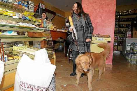 Patricia Carracal comprando el pan con su perro Brilyn. | M. Álvarez