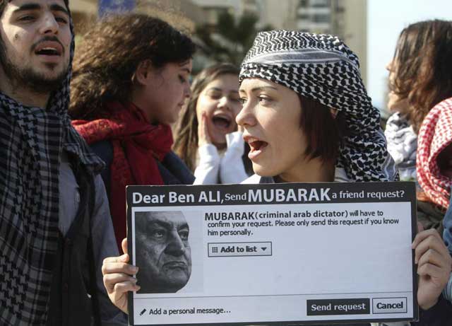 Una manifestante anti Mubarak muestra su protesta haciendo un guio a Facebook. | Reuters