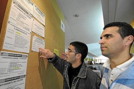 Dos jóvenes leen las ofertas de empleo en Soria. | EL MUNDO