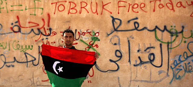 Un opositor al régimen sostiene la bandera libia previa a la 'era Gadafi' en Tobruk. | AFP