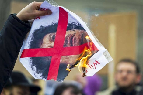 Un manifestante quema una imagen de Gadafi en La Haya.| Efe