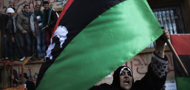 Una manifestante ondea la vieja bandera en Bengasi.| Afp