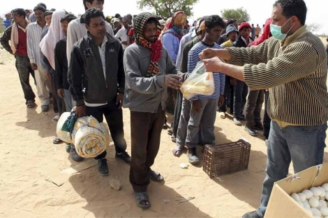 Voluntarios reparten comida en el campamento de Ras el Jedir. | Efe