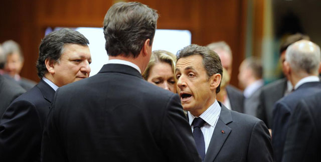 El presidente Sarkozy conversa con Cameron ante la mirada de Duro Barroso, en Bruselas. | Afp