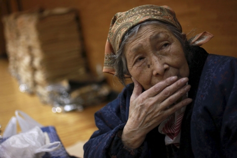 Una anciana de 80 años descansa en un centro de evacuación de Japón. | Efe