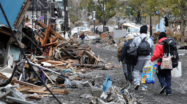 Supervivientes del tsunami caminan por una zona de casas desvastadas en la ciudad de Kamaishi. | Afp
