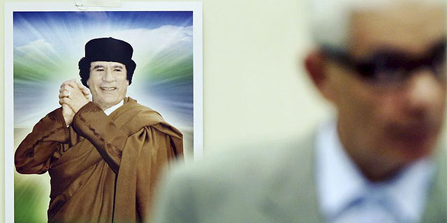 Una imagen de Muamar Gadafi, tras el ministro de exteriores libio, Musa Kusa. (AFP)