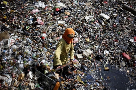 Un trabajador recolecta basura en un ro contaminado de Yakarta (Indonesia). | Mast Irham/Efe