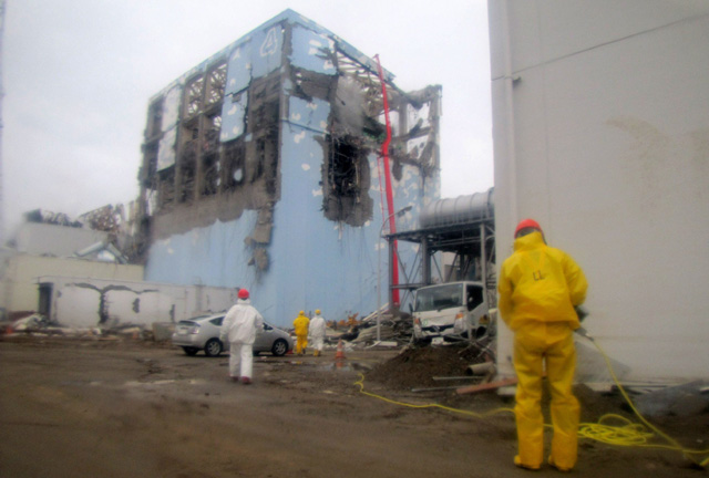Trabajadores echan agua en el reactor 4 de Fukushima. | Afp