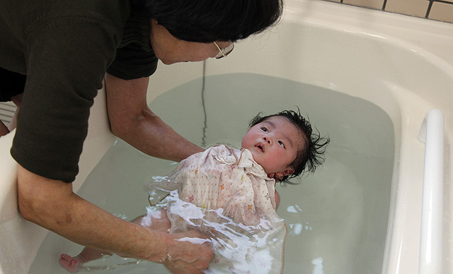 Una mujer baña a una niña en la ciudad de Okuma, en la prefectura de Fukushima. | Afp