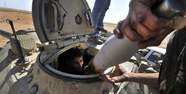Un rebelde libio en un tanque de las fuerzas de Gadafi, cerca de la ciudad de Ajdabiya. | AFP MS FOTOS