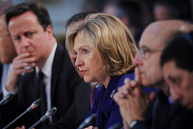 Cameron (izda.) sigue atento la intervencin de Clinton en la Conferencia de Londres sobre Libia. | Efe