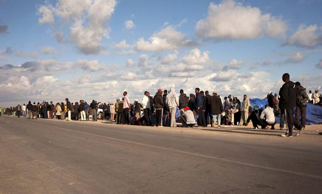 Un grupo de inmigrantes esperan el autobs que los saque de Libia.| Laura Len