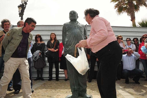 Flores y arenques para homenajear a Fernando Quiones ante su estatua. | Cata Zambrano