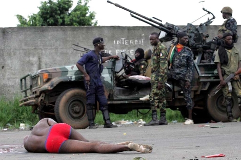 Fuerzas de Ouattara, junto a un muerto, cerca del palacio presidencial, en Abiyn.| Reuters