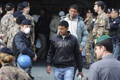 Inmigrantes procedentes de Lampedusa desembarcan de un buque militar en Npoles. | Efe